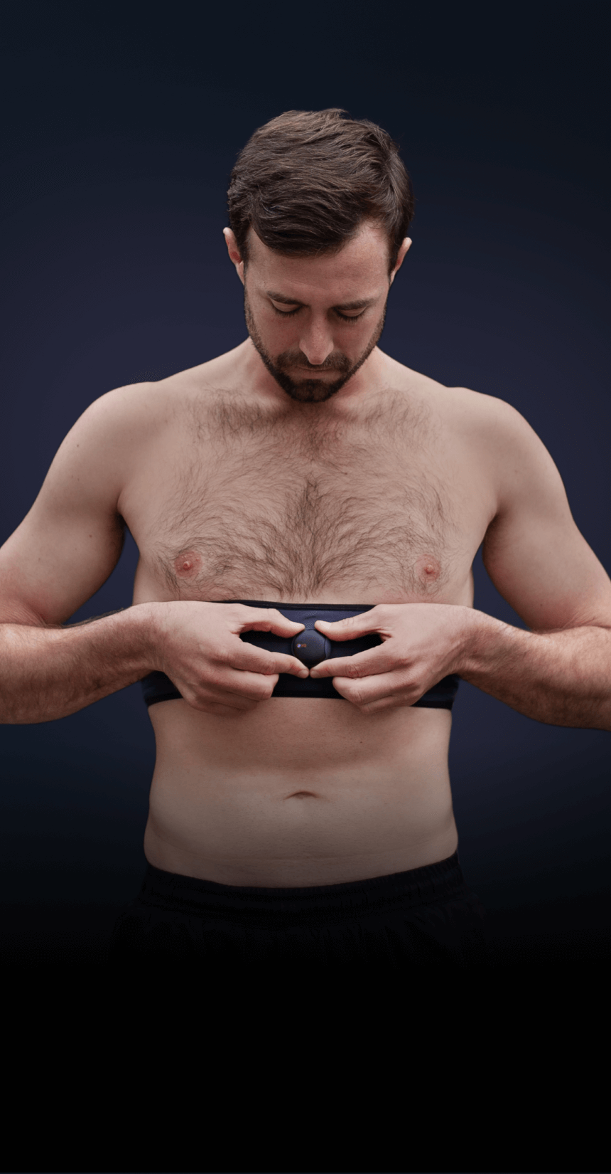  Man outdoors, attaching the Oxa breathing coach device to his waistband preparing for a focused breathing session to enhance his wellbeing and resilience.